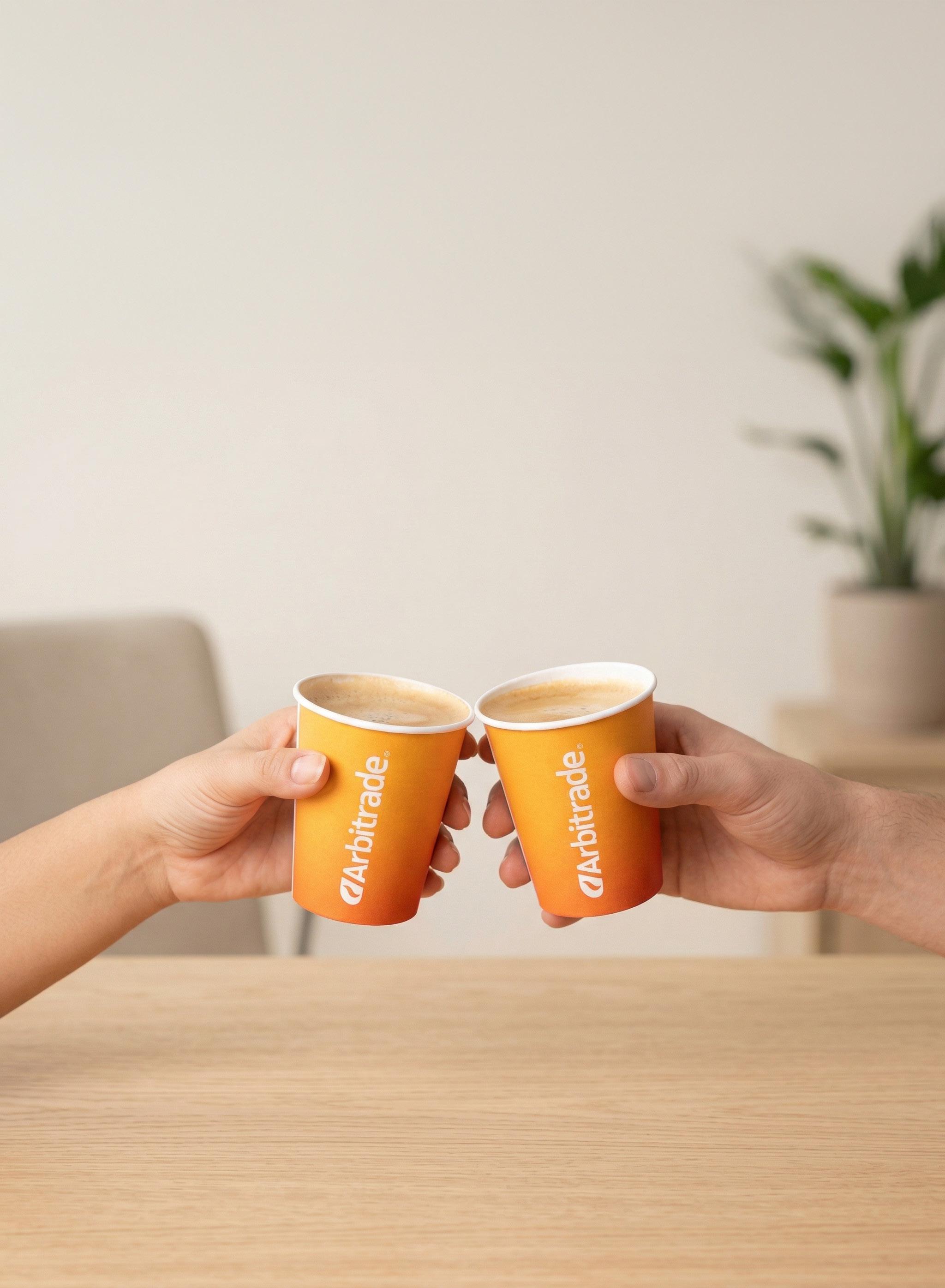 Dos personas brindando con vasos Arbitrade
