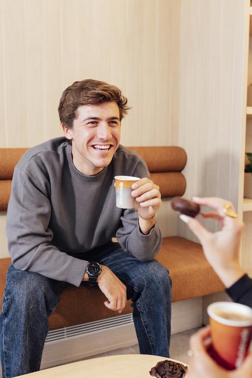 Persona disfrutando café Arbitrade en sofá